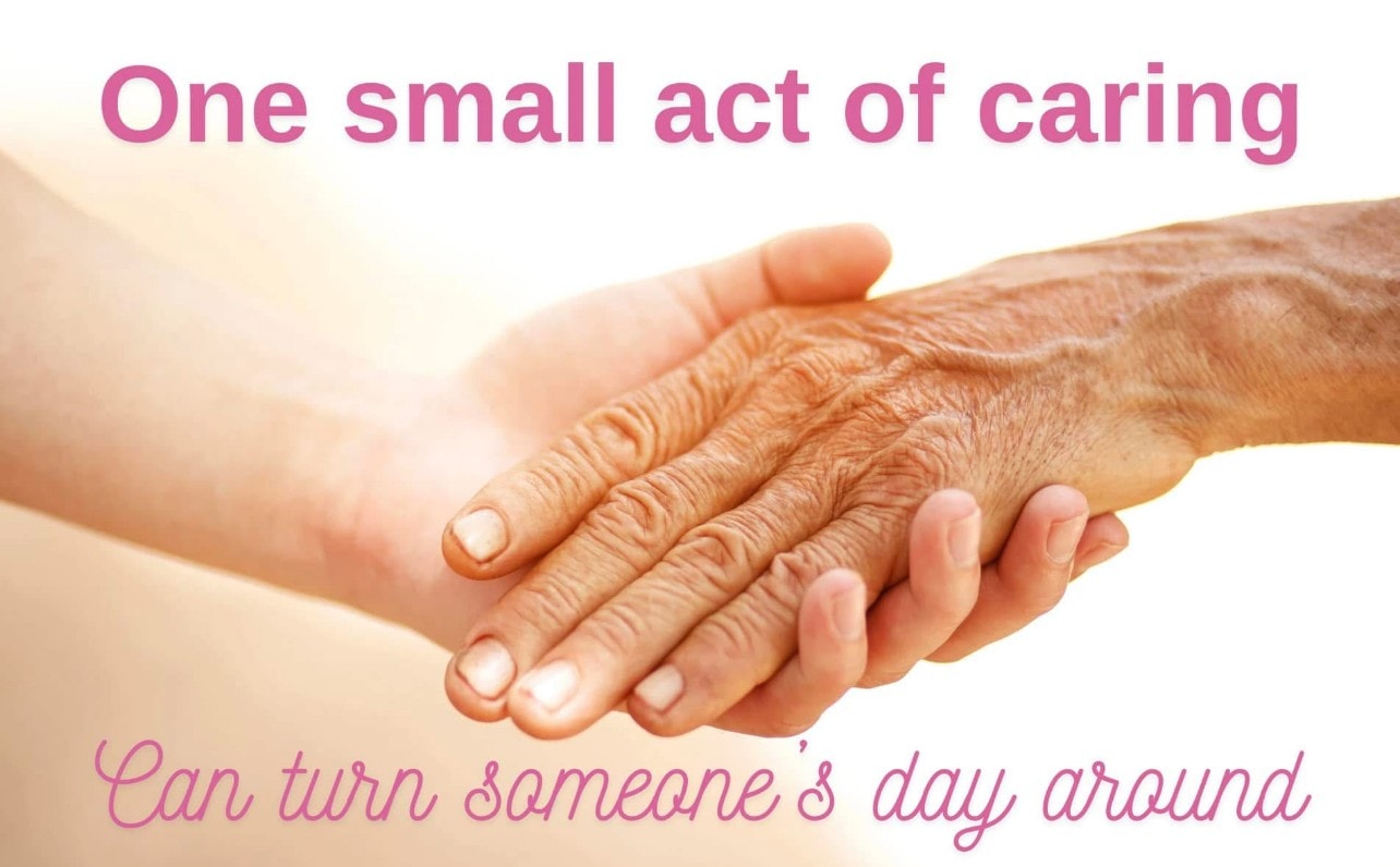 Carer holding elderly client's hand with compassion